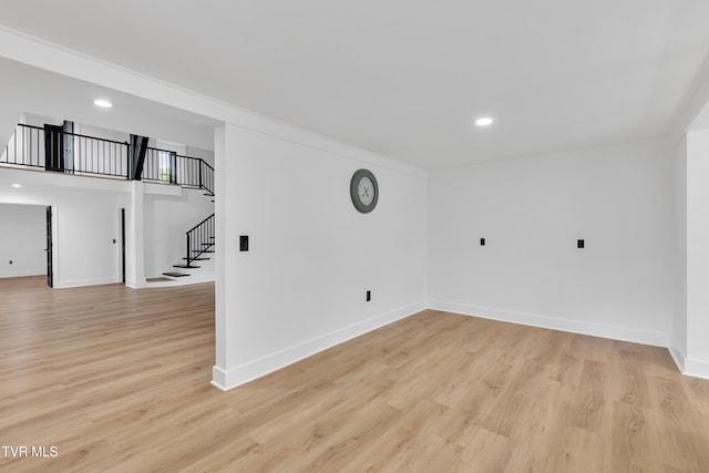 spare room featuring stairway, recessed lighting, baseboards, and light wood-type flooring