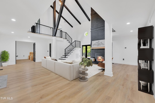 120 Brookfield Dr, Kingsport, TN 37663 - living room featuring a high ceiling, stairway, a fireplace, wood finished floors, and baseboards