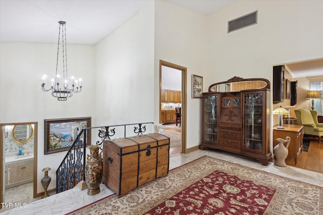 entryway featuring a towering ceiling, a chandelier, and baseboards