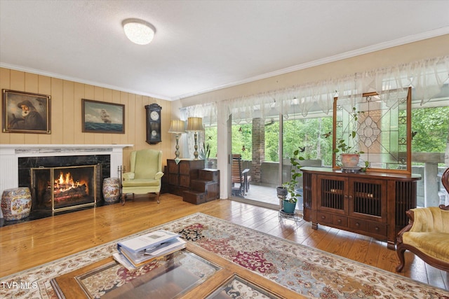 living room with crown molding, hardwood / wood-style flooring, and a premium fireplace