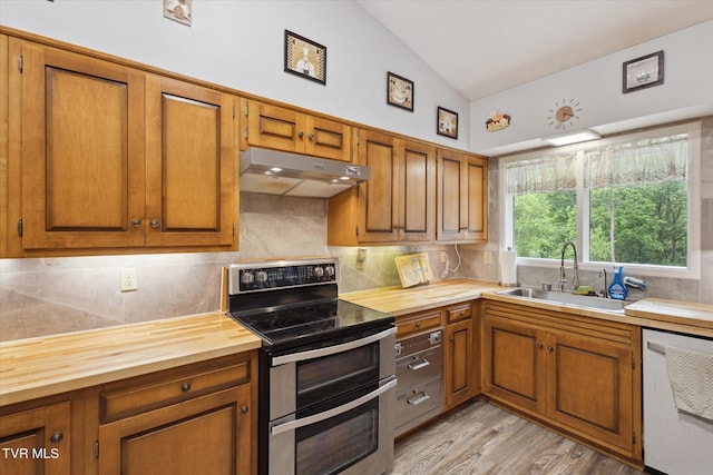 kitchen featuring range with two ovens, under cabinet range hood, dishwashing machine, butcher block countertops, and a sink
