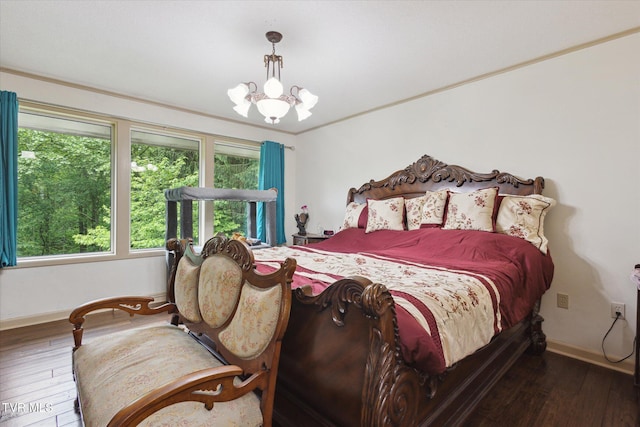 bedroom with hardwood / wood-style floors, a chandelier, and baseboards