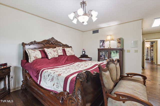 bedroom featuring a chandelier, hardwood / wood-style floors, and baseboards