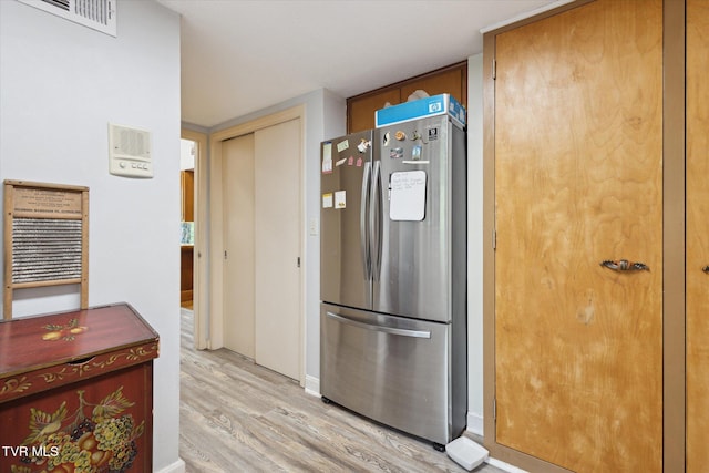 kitchen with freestanding refrigerator and light wood-style floors