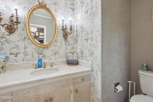 half bath with wallpapered walls, toilet, and vanity