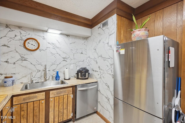 kitchen with stainless steel appliances, a sink, light countertops, decorative backsplash, and brown cabinetry