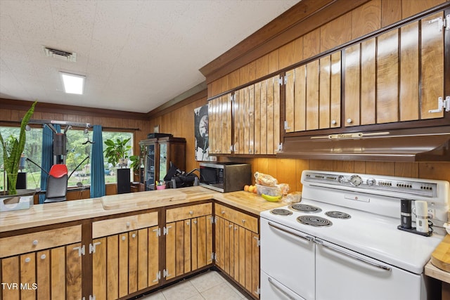 kitchen with white electric stove, stainless steel microwave, wooden walls, wood counters, and under cabinet range hood