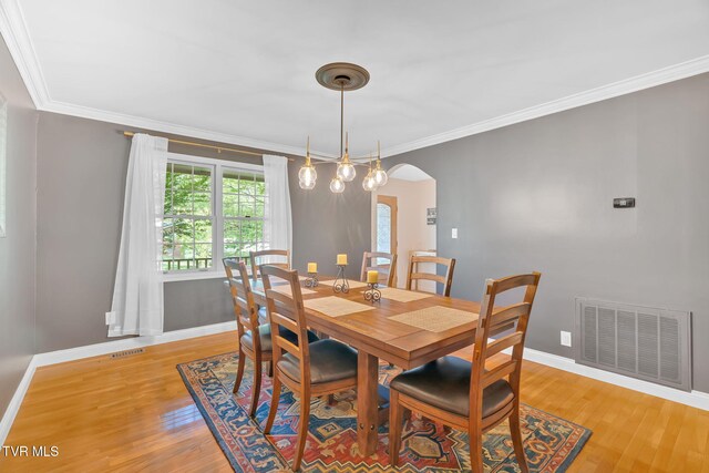 588 Spring Valley Rd, Bristol, VA 24201 - dining room featuring light wood-type flooring, arched walkways, crown molding, and baseboards