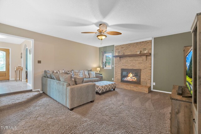 588 Spring Valley Rd, Bristol, VA 24201 - carpeted living room featuring ceiling fan, a brick fireplace, a textured ceiling, and baseboards