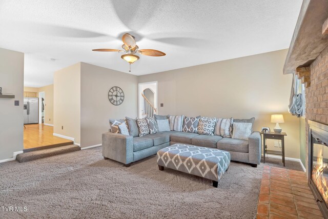 588 Spring Valley Rd, Bristol, VA 24201 - carpeted living area featuring a brick fireplace, a ceiling fan, baseboards, and a textured ceiling