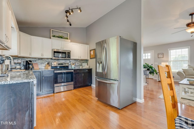 kitchen with appliances with stainless steel finishes, a sink, a ceiling fan, tasteful backsplash, and white cabinetry