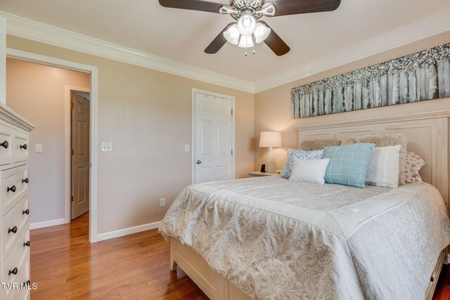 bedroom featuring light wood finished floors, baseboards, ornamental molding, and a ceiling fan