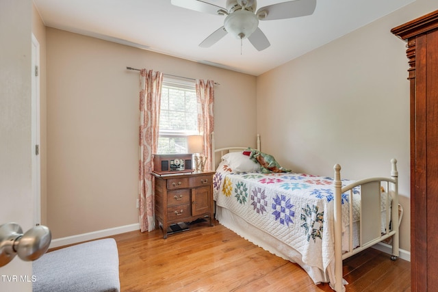 bedroom with light wood-style flooring, baseboards, and a ceiling fan