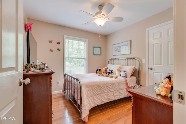 bedroom with light wood-style flooring, ceiling fan, and baseboards