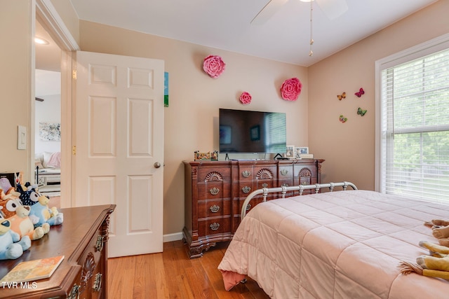 bedroom with light wood finished floors, baseboards, and a ceiling fan