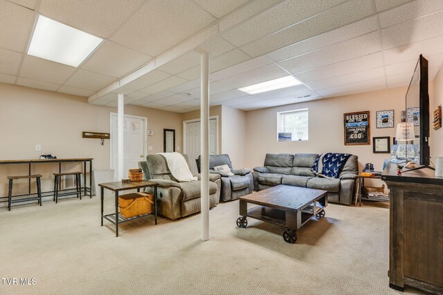 living room with carpet flooring and a paneled ceiling