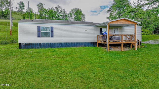 back of property with a wooden deck and a yard