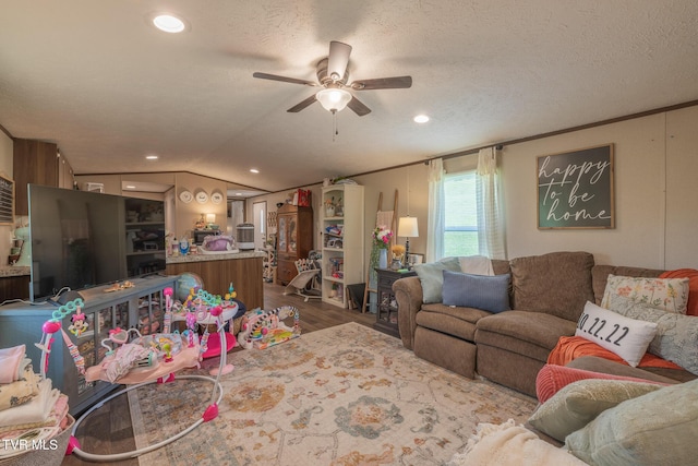 living area featuring a ceiling fan, lofted ceiling, wood finished floors, recessed lighting, and a textured ceiling
