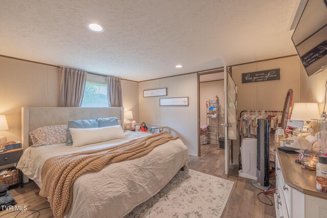 bedroom featuring a textured ceiling, wood finished floors, and recessed lighting