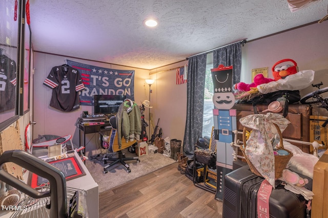 playroom with a textured ceiling and wood finished floors