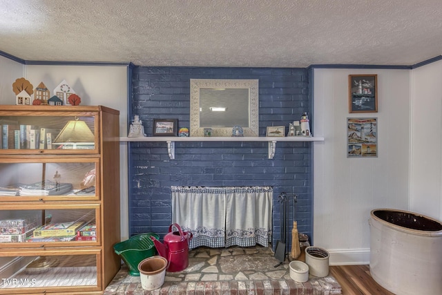 629 Buffalo Rd, Blountville, TN 37617 - detailed view of a textured ceiling, wood finished floors, a brick fireplace, baseboards, and ornamental molding