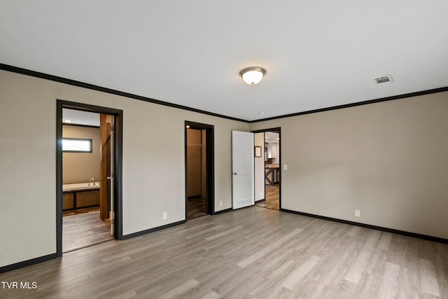 2551 Cedar Creek Rd, Russellville, TN 37860 - unfurnished bedroom with light wood-style floors, ornamental molding, a walk in closet, baseboards, and connected bathroom