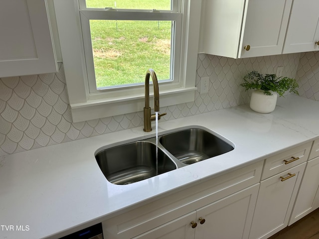 8467 Rich Valley Rd, Bristol, VA 24202 - kitchen view of a sink, white cabinetry, backsplash, and light stone counters