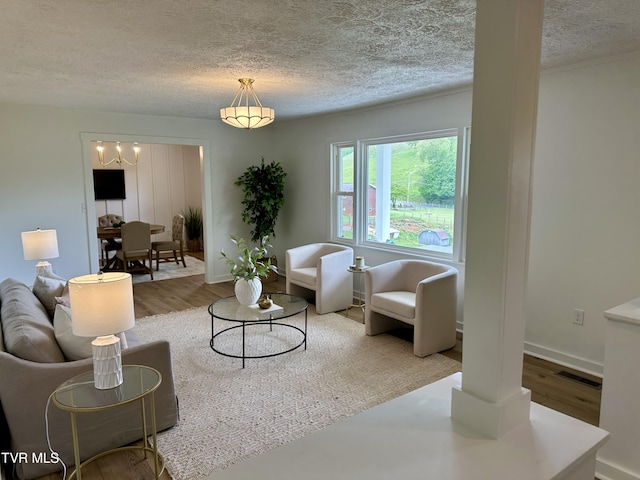 8467 Rich Valley Rd, Bristol, VA 24202 - living room with a textured ceiling, wood finished floors, baseboards, and a chandelier