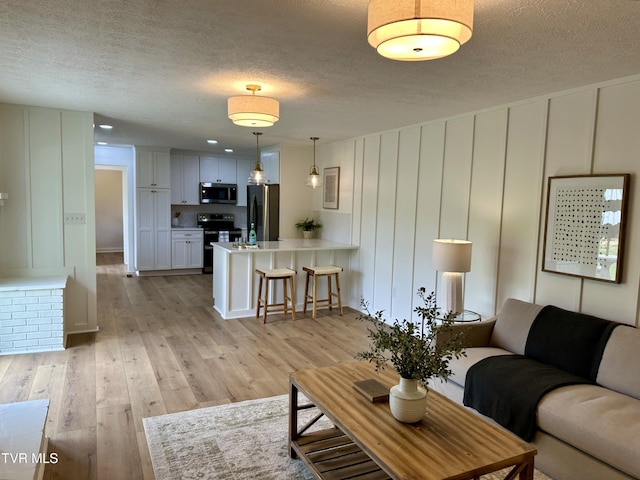 8467 Rich Valley Rd, Bristol, VA 24202 - living room featuring a decorative wall, a textured ceiling, and light wood-type flooring