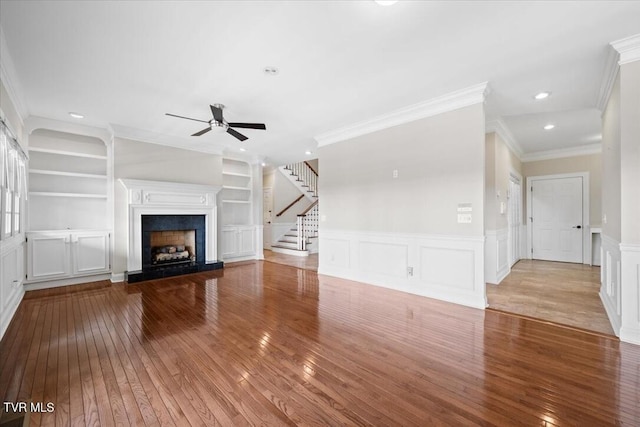 15127 Stonewall Rdg, Bristol, VA 24202 - unfurnished living room featuring wood-type flooring, ornamental molding, a ceiling fan, a fireplace with raised hearth, and stairs