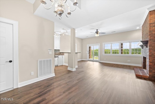 15127 Stonewall Rdg, Bristol, VA 24202 - unfurnished living room featuring dark wood-style flooring, a chandelier, a brick fireplace, and baseboards