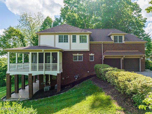15127 Stonewall Rdg, Bristol, VA 24202 - view of front of house featuring a sunroom, central air condition unit, a front lawn, an attached garage, and brick siding