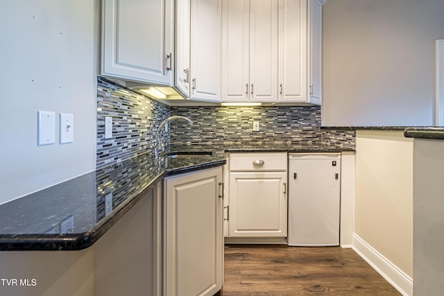 15127 Stonewall Rdg, Bristol, VA 24202 - kitchen with dark wood-type flooring, decorative backsplash, white cabinets, and dark stone counters