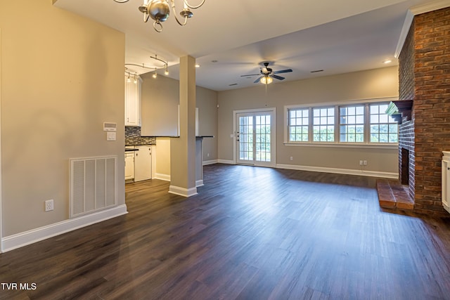15127 Stonewall Rdg, Bristol, VA 24202 - unfurnished living room with a chandelier, a brick fireplace, ceiling fan, and dark wood-style floors