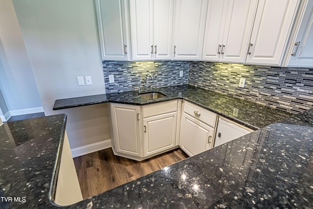 15127 Stonewall Rdg, Bristol, VA 24202 - kitchen featuring dark wood-style floors, white cabinets, decorative backsplash, and dark stone countertops