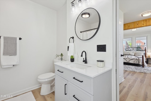 2504 Fort Henry Dr, Kingsport, TN 37664 - bathroom featuring wood finished floors, toilet, vanity, connected bathroom, and baseboards