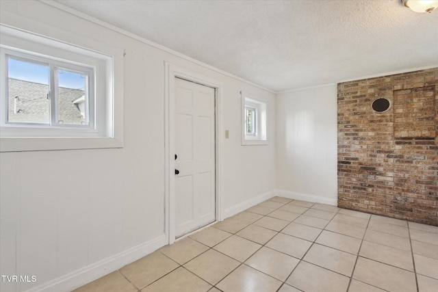 2504 Fort Henry Dr, Kingsport, TN 37664 - entryway with brick wall, crown molding, a textured ceiling, light tile patterned flooring, and baseboards