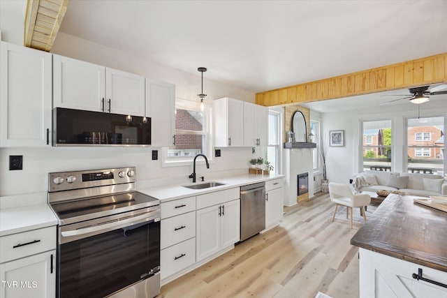 2504 Fort Henry Dr, Kingsport, TN 37664 - kitchen with appliances with stainless steel finishes, a sink, open floor plan, light wood-type flooring, and white cabinetry