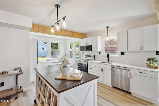2504 Fort Henry Dr, Kingsport, TN 37664 - kitchen featuring appliances with stainless steel finishes, a sink, light wood-type flooring, and white cabinets