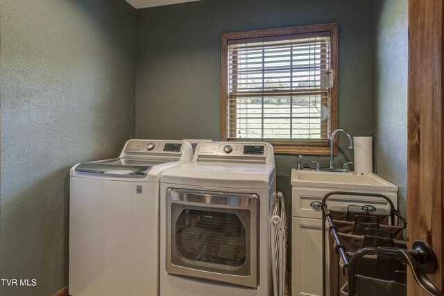 138 Ray Cemetery Rd, Roan Mountain, TN 37687 - clothes washing area featuring washer and dryer, cabinet space, and a textured wall