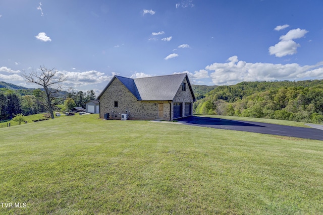 138 Ray Cemetery Rd, Roan Mountain, TN 37687 - view of side of property with asphalt driveway, a lawn, an outdoor structure, and a view of trees