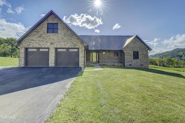 138 Ray Cemetery Rd, Roan Mountain, TN 37687 - tudor-style house featuring brick siding, asphalt driveway, a front lawn, and a garage