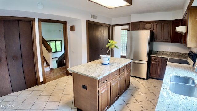 15 Crown Cir Unit 15, Kingsport, TN 37660 - kitchen with freestanding refrigerator, light tile patterned floors, a kitchen island, a sink, and light stone countertops