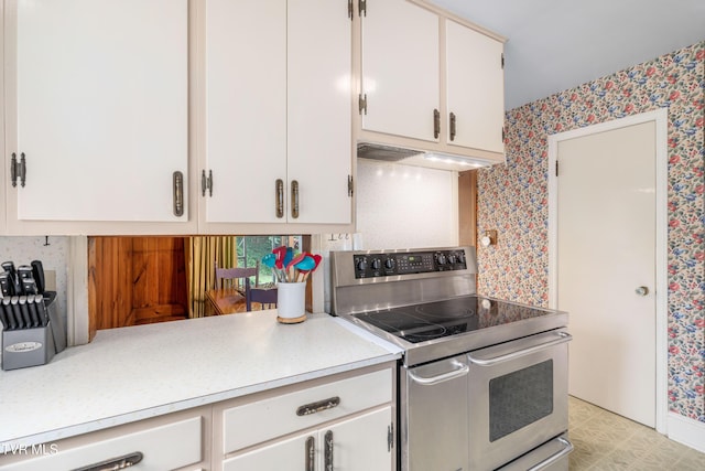 134 Parkland Dr, Bristol, VA 24201 - kitchen featuring double oven range, wallpapered walls, under cabinet range hood, light countertops, and white cabinetry