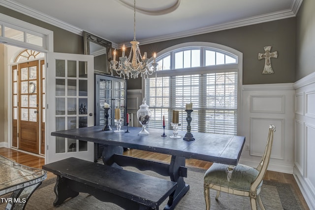 2909 Greenline Rd, Johnson City, TN 37604 - dining area featuring a decorative wall, a chandelier, crown molding, a wainscoted wall, and wood finished floors