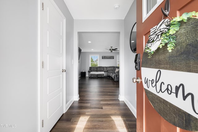 hallway featuring dark wood-style floors, baseboards, and recessed lighting