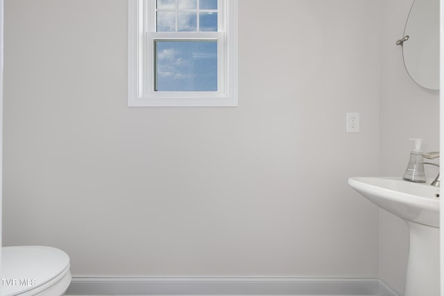 bathroom with baseboards and toilet