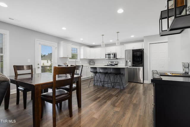 dining space with recessed lighting, dark wood-style floors, and baseboards
