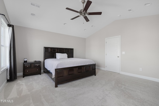 bedroom with vaulted ceiling, light colored carpet, multiple windows, and baseboards