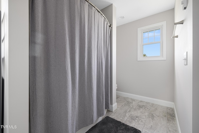 bathroom with baseboards and toilet